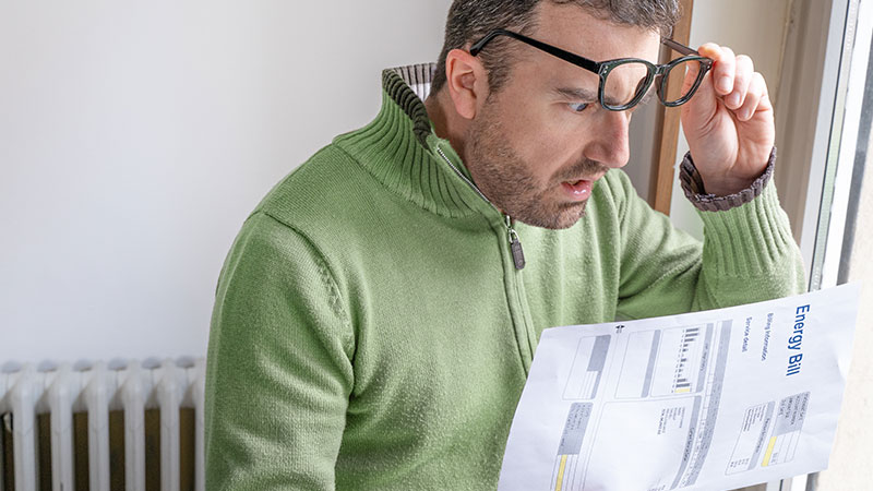 uomo legge stupito la bolletta